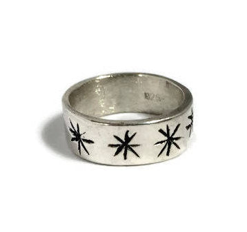 Wide band ring with carved asterix stars in silver.