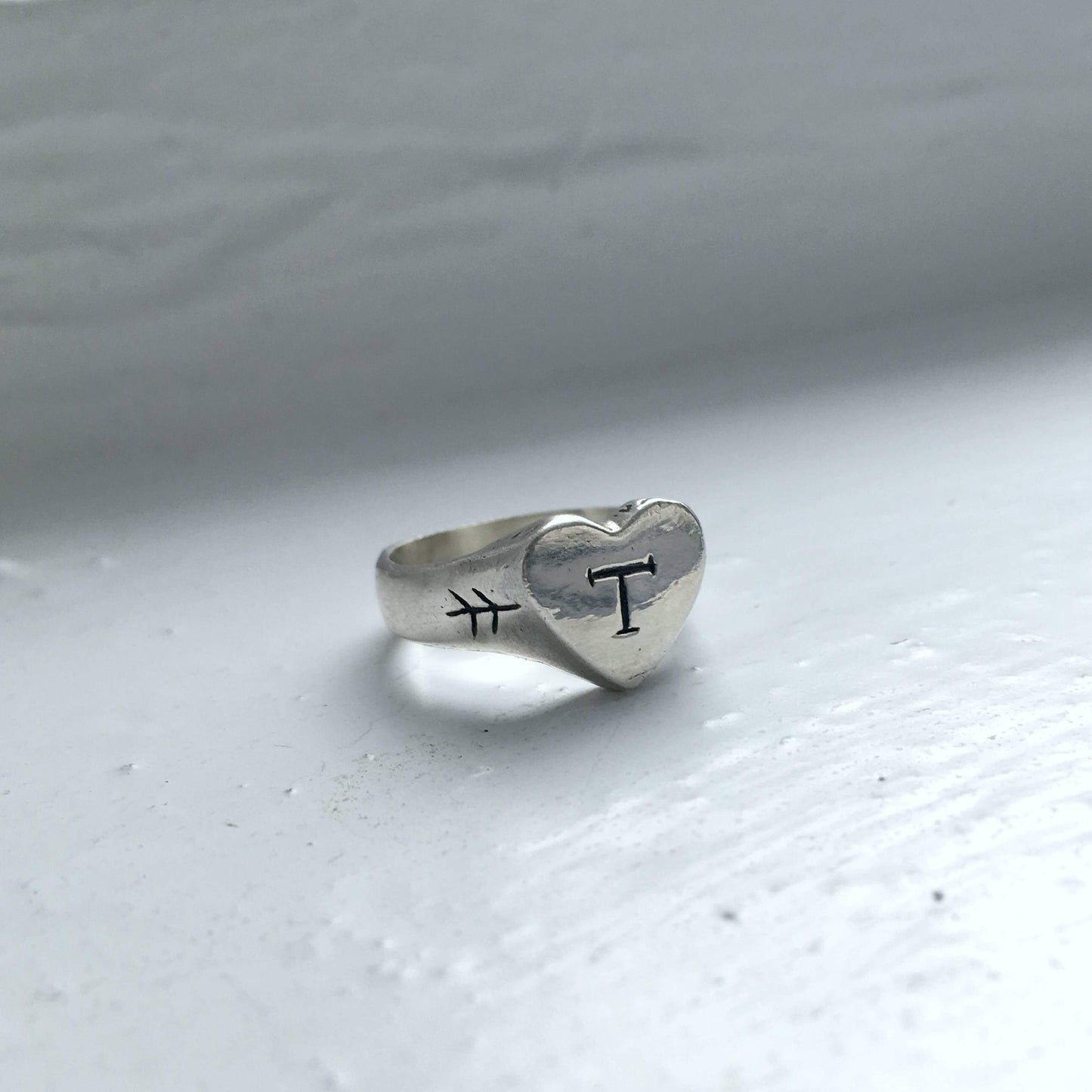 silver heart-shaped signet ring with engraved initial
