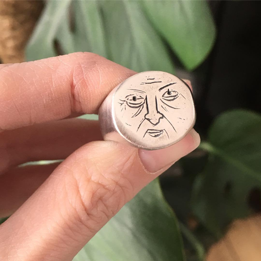 chunky round signet ring with a unique grumpy face
