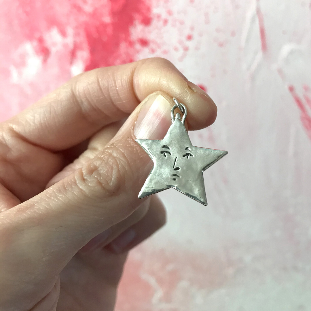 large sterling silver star pendant with a face